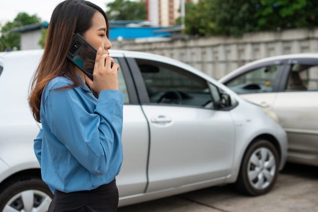 A woman on the phone after a car accident.
